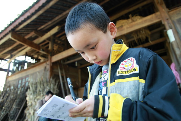 8当年八岁的吴守凡换上杨霁买的新衣服，一丝不苟的用笔写下“气象妈妈”的名字.JPG