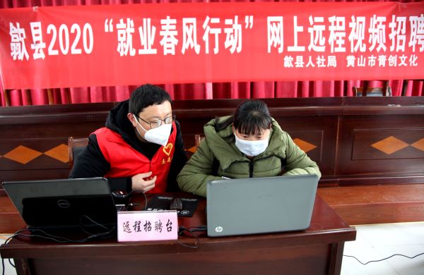 3、黄山市青创文化传播有限公司志愿者仰时威（左二）在指导老区农民选岗位。.jpg