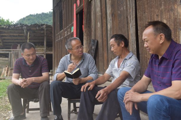 胡明发（左二）走访村里的贫困户。.JPG