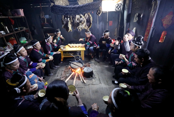 1月19日，在三江侗族自治县良口乡良帽村，村民们在围着火塘吃油茶。.jpg
