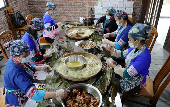 5月15日，在三江侗族自治县斗江镇牙林村盛龙风情园，几名妇女在包粽子。1.jpg